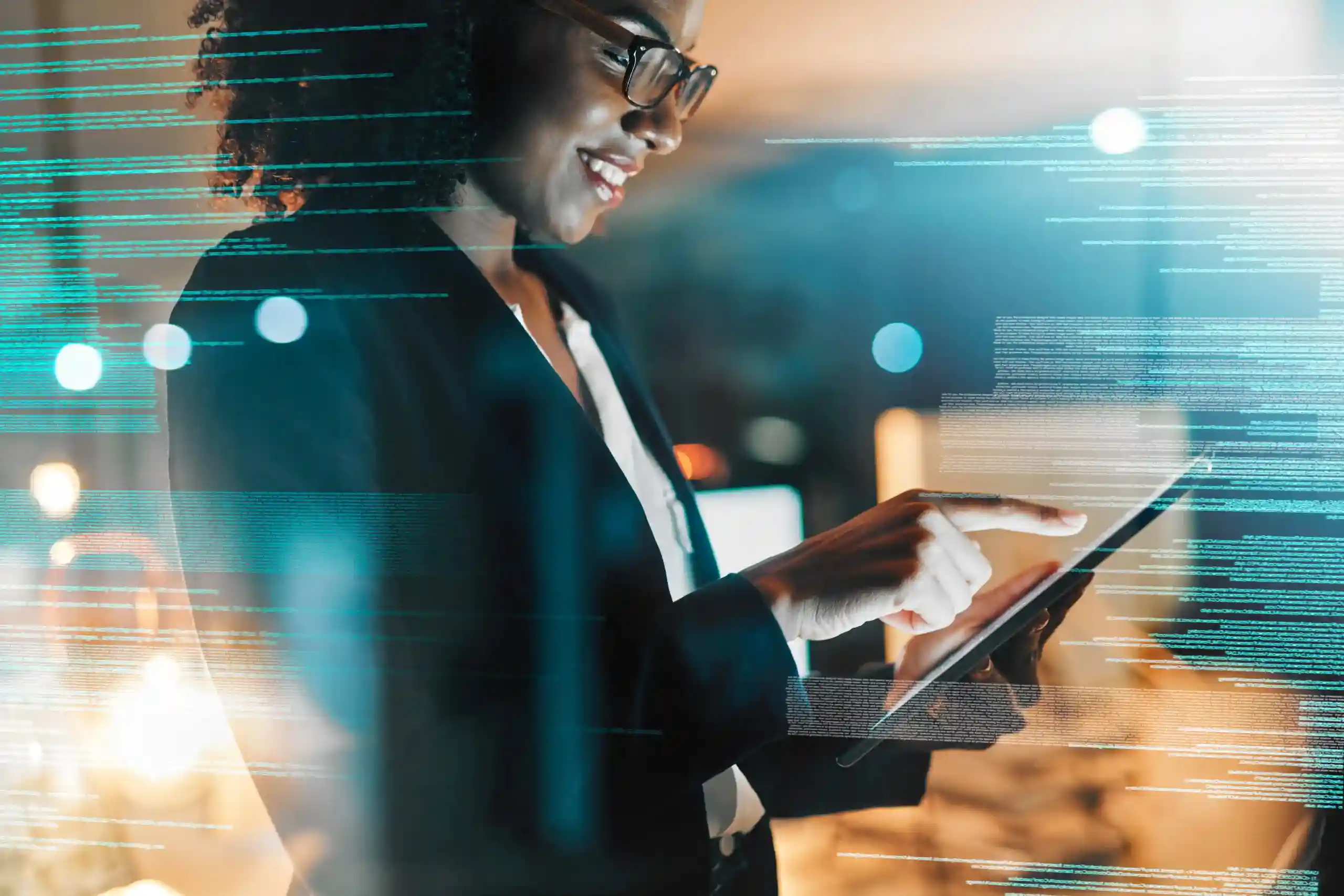 A smiling professional wearing a blazer and glasses using a digital tablet, overlaid with glowing teal lines of computer code.